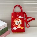 Détail du sac dragon tricoté rouge avec bouton cœur et texture de poignée tissée - Dragon de Bande Dessinée Rouge