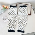Close-up of white sun sleeves with black letter patterns and golden elastic cuffs - Letter a (5 Simple-a)