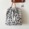 Dettaglio della borsa tote floreale in tessuto seersucker con manici in corda arancio - Adesivo Fiore Nero Bianco