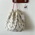 Detail of floral tote bag with cream puckered fabric and pink woven rope handles - Hoya Beige