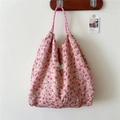Detailed view of pink floral tote bag fabric texture with braided rope shoulder strap - Rose Pink Flower