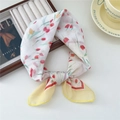 Elegant white silk scarf with red tulip print and yellow hem on a wooden tray - Tulip Duo Frame Yellow