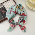 Floral mint green small silk scarf with red and yellow flowers in a lifestyle setting - Faulted Flower Green