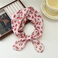 Pink floral cotton scarf with cherry patterns tied in a bow on a lifestyle background - Two Three Cherries