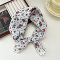 Breathable floral cotton scarf with red and yellow blossoms tied in a bow knot style - Buddleja Red
