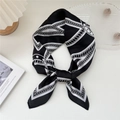 Elegante foulard in seta a catena bianco e nero annodato in modo raffinato e moderno - Corda Film Ferro di Cavallo Nero