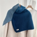 Détail d'un cache-cou en grosse maille à col roulé avec fentes et étiquette tissée authentique - Bloc de Couleur Bleue