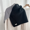 Detail of chunky ribbed knit neck warmer featuring a brand label and autumn texture - Black Grey Patchwork
