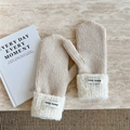 Close-up of beige knitted mittens with plush white faux shearling cuffs and brand label - Beige