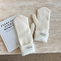 Detail of knitted mittens with fluffy fleece cuffs and minimalist fabric brand label - Creamy White