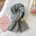 Close-up of light gray chunky knit scarf with thick ribbed texture and woven brand label - Gray