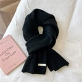 Detailed view of black chunky knit scarf with vertical stripes and woven label - 21x165cm / Heathered Black