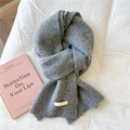 Close-up of grey knitted scarf with soft vertical texture and stitched brand label - 21x165cm / Grey Melange