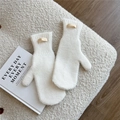 Nahaufnahme weißer Strickfäustlinge mit weichem Plüschsaum und Leder-Markenetikett - Cremeweiß