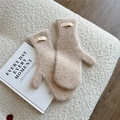 Nahaufnahme beiger Strickfäustlinge mit Doria Dore Label auf weichem Hintergrund - Haferflocken