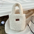 Dettaglio della borsa a mano in peluche con toppa in pelle marrone sull'erba - Bianco Latte (2HSM)