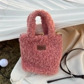 Detailed view of pink plush crossbody bag featuring brown leather logo and metallic strap - Pink (11HSM)