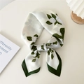 Elegant ivory floral silk scarf with green edges tied in a stylish necktie knot - Golden Chain White Rose