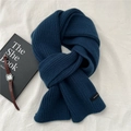 Detail eines dunkelblauen Wollschals mit 100 % Wollsiegel und Rippstrick-Textur - Marineblau