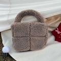 Detail of plush brown quilted handbag with soft faux fur texture and sturdy round handles - Gray