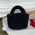 Close-up of black fuzzy tote bag featuring plush cross-stitch quilted texture and soft handle - Black