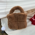 Detail shot of brown plush woven tote bag with soft faux shearling texture and thick grid design - Camel