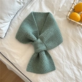 Detailed knit texture of green scarf with cross-slot design on a white bed sheet - Light Green