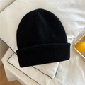Detail of black ribbed knit beanie showing soft texture on a clean white surface - One Size / Black