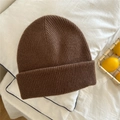 Detail of a brown knit beanie with vertical ribbed pattern on a soft white background - One Size / Brown