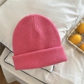 Detail of a pink ribbed knit beanie with thick cuffs on a white bedding background - One Size / Peach