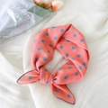 Foulard en soie rose corail à pois bleus présenté avec un arrangement floral élégant - 4B Pois Rose