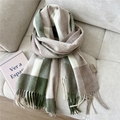 Close-up of thick plaid wool scarf with fringe on sofa, showing soft woven texture - Wool Long Plaid Green