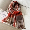 Detail of warm orange and brown plaid wool scarf with fringes on a grey sofa - Wool Double Line Red
