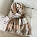 Detail view of wool-like plaid scarf with handmade fringe on a soft gray sofa - Wool Double Line Khaki