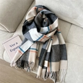 Detailed shot of a soft wool blend plaid scarf with tassels on a neutral fabric background - Wool Double Line Gray