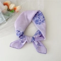 Foulard en coton et lin lilas à motif paisley noué sur un fond blanc épuré - Paisley Violet