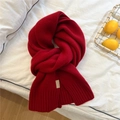 Detail of red thick knit wool scarf featuring a 100% wool label on white bedding - Red - Small Leather Label Style (30*170cm)