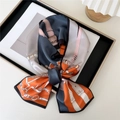 Narrow silk scarf featuring orange and blue chain prints tied in a classic knot - Belt Chain Splice Orange Blue