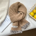 Detail of brown chunky knit scarf with faux fur trim and woven label on a white surface - 20cmx152cm / Camel