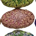 Close-up of stacked luxury evening clutches featuring intricate crystal floral leaf patterns - Pink