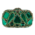 Macro shot of emerald gemstones and black diamonds on a luxury gold evening clutch bag - Green