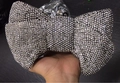Detailed close-up of a bow-shaped evening clutch with sparkling silver crystal rhinestones - Black With White Rhinestone