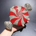 Detailed close-up of candy-shaped clutch bag with red and white rhinestone spiral pattern - Red