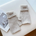 Close-up of beige cable knit fingerless gloves with a leather logo patch on white fabric - One Size / Beige