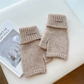 Detailed close-up of beige cable knit fingerless gloves with a brown leather logo patch - One Size / Khaki