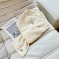 Detail of soft cream knitted scarf texture with a small metal plate on leather sofa - Cream