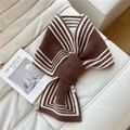 Dettaglio di sciarpa in maglia a righe marroni e bianche con design incrociato e trama - Marrone a Righe