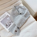 Detail showing soft light grey knit scarf texture with metal DD logo tag on fabric - Light Gray