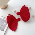 Detail of red cable-knit hat featuring thick ribbed cuffs and a white woven brand label - One Size / Red