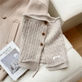 Detail of oatmeal knit neck gaiter showing cable texture and wooden buttons - Beige